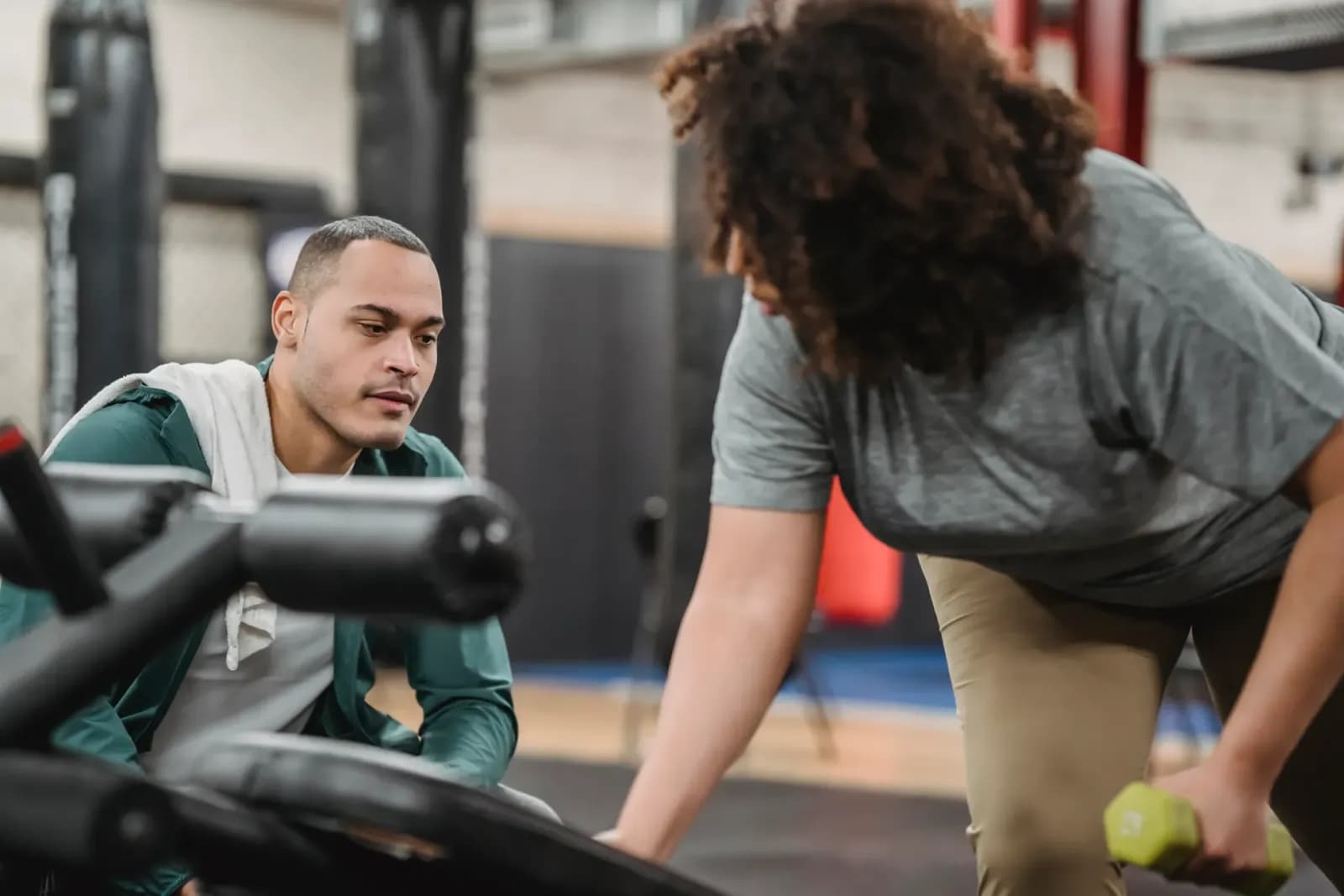 Spor salonunda ders veren profesyonel fitness antrenörü, masanın üzerinde duran modern bir antrenör CV'si, elinde tablet tutan spor eğitmeni