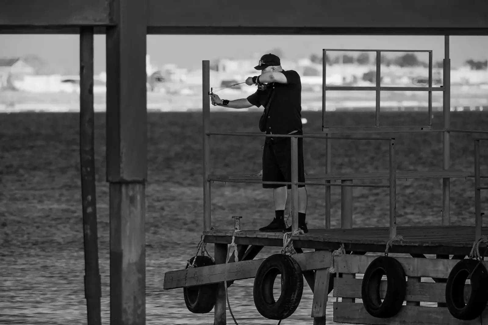 Monochrome image of a man taking a photo on a pier in Aktau, Kazakhstan at the Caspian Sea.