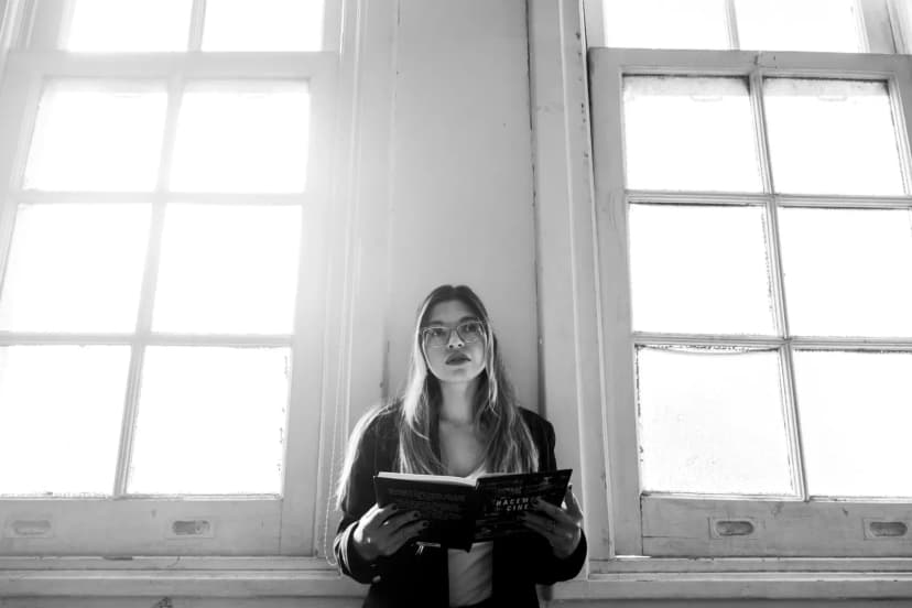 Black and white photo of a young woman reading in a university setting, Buenos Aires.