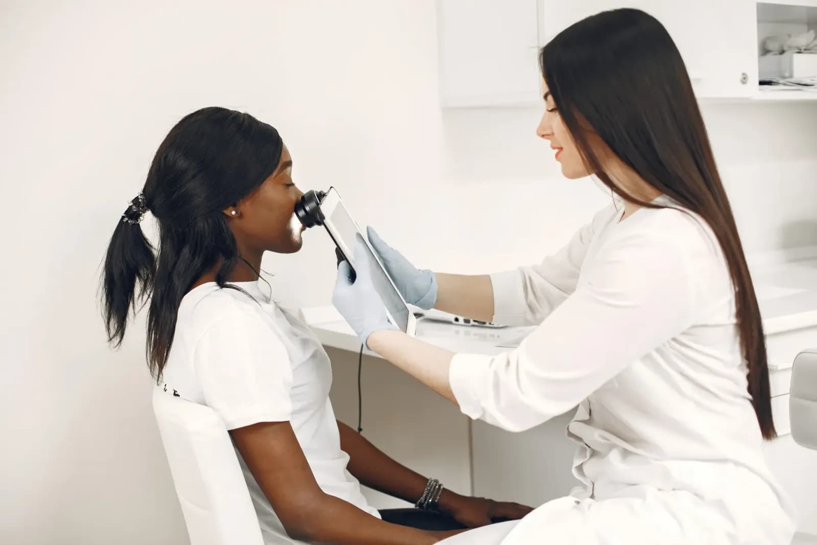 Dermatolog hasta muayenesi sırasında cilt kontrolü yapıyor
