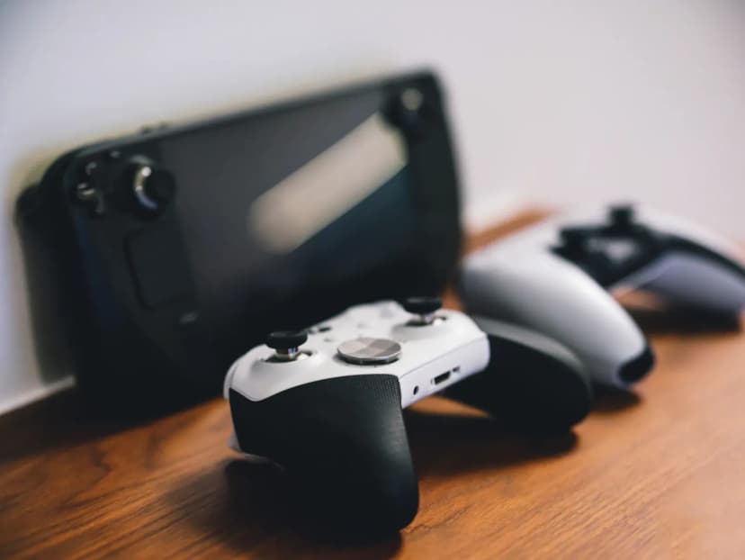 Stylish setup of gaming controllers and console on wooden surface.