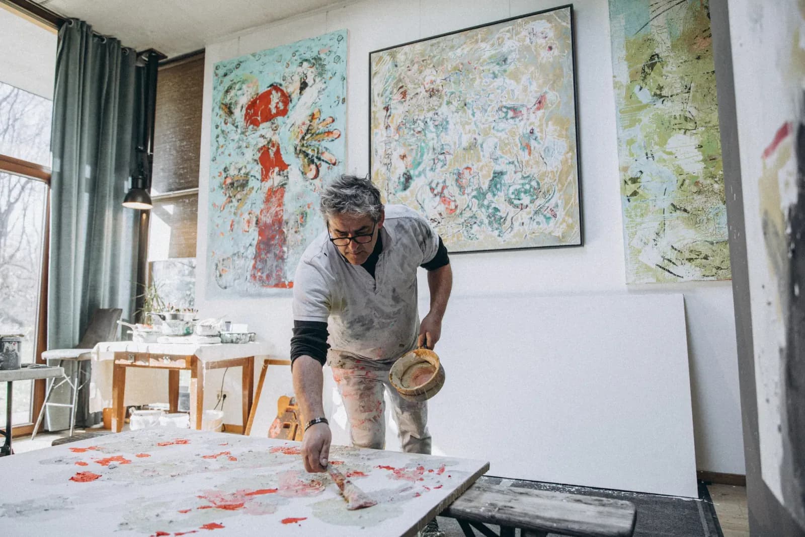 Stüdyosunda tuval üzerinde çalışan ressam