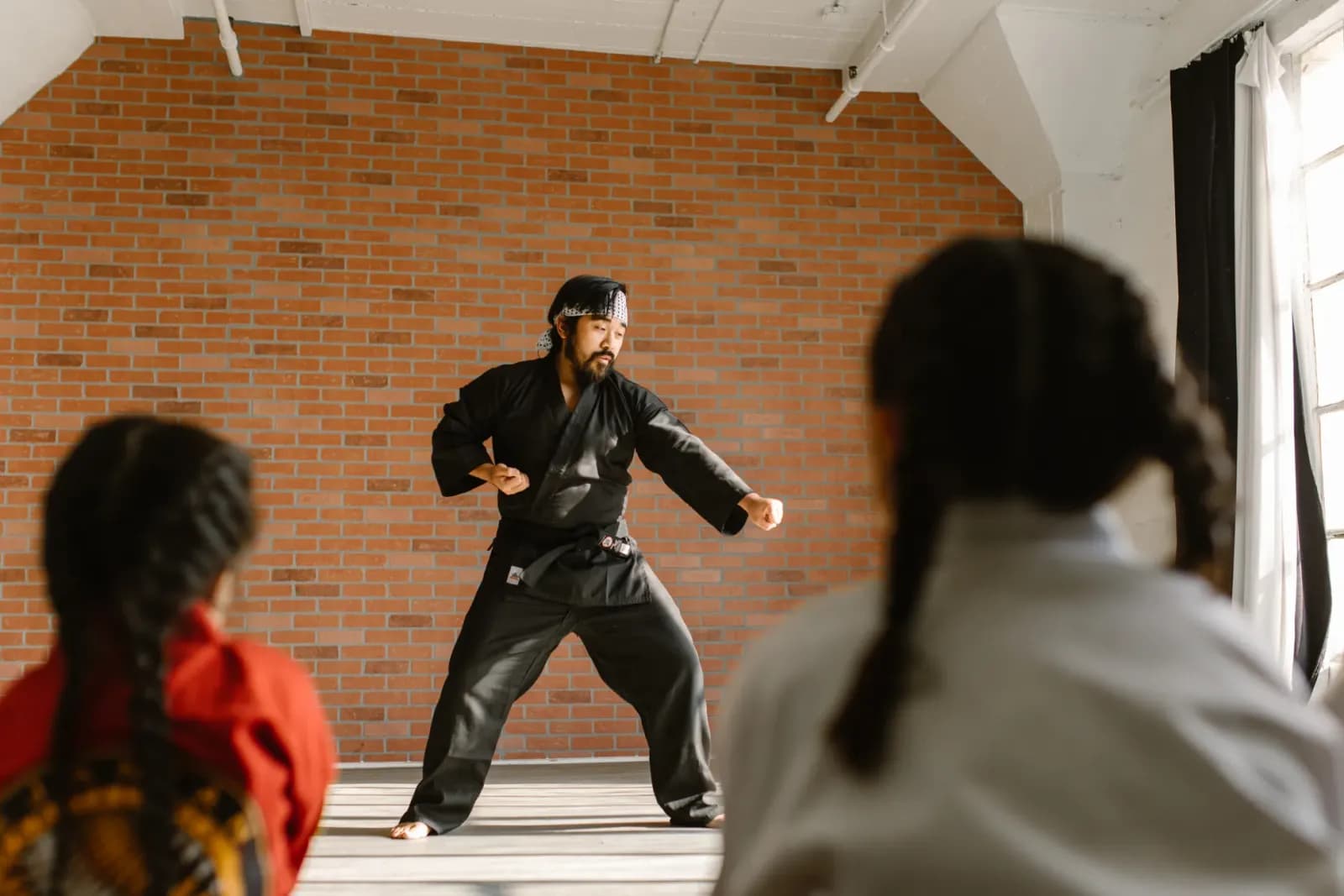 dövüş sanatları eğitmeni öğrencilerine ders verirken, spor salonunda antrenman yapan karate eğitmeni, profesyonel spor eğitmeni teknik gösterisi yaparken