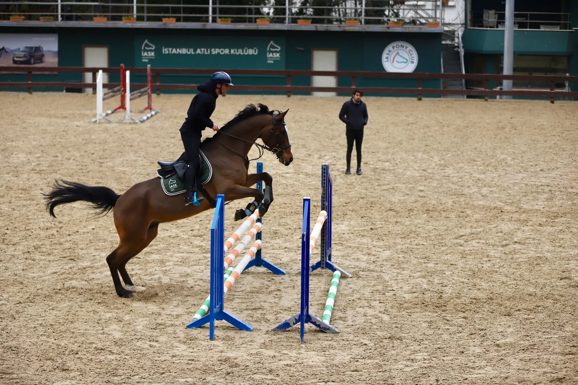 A horse and rider perform a jump at the Istanbul Horse Sports Club arena.
