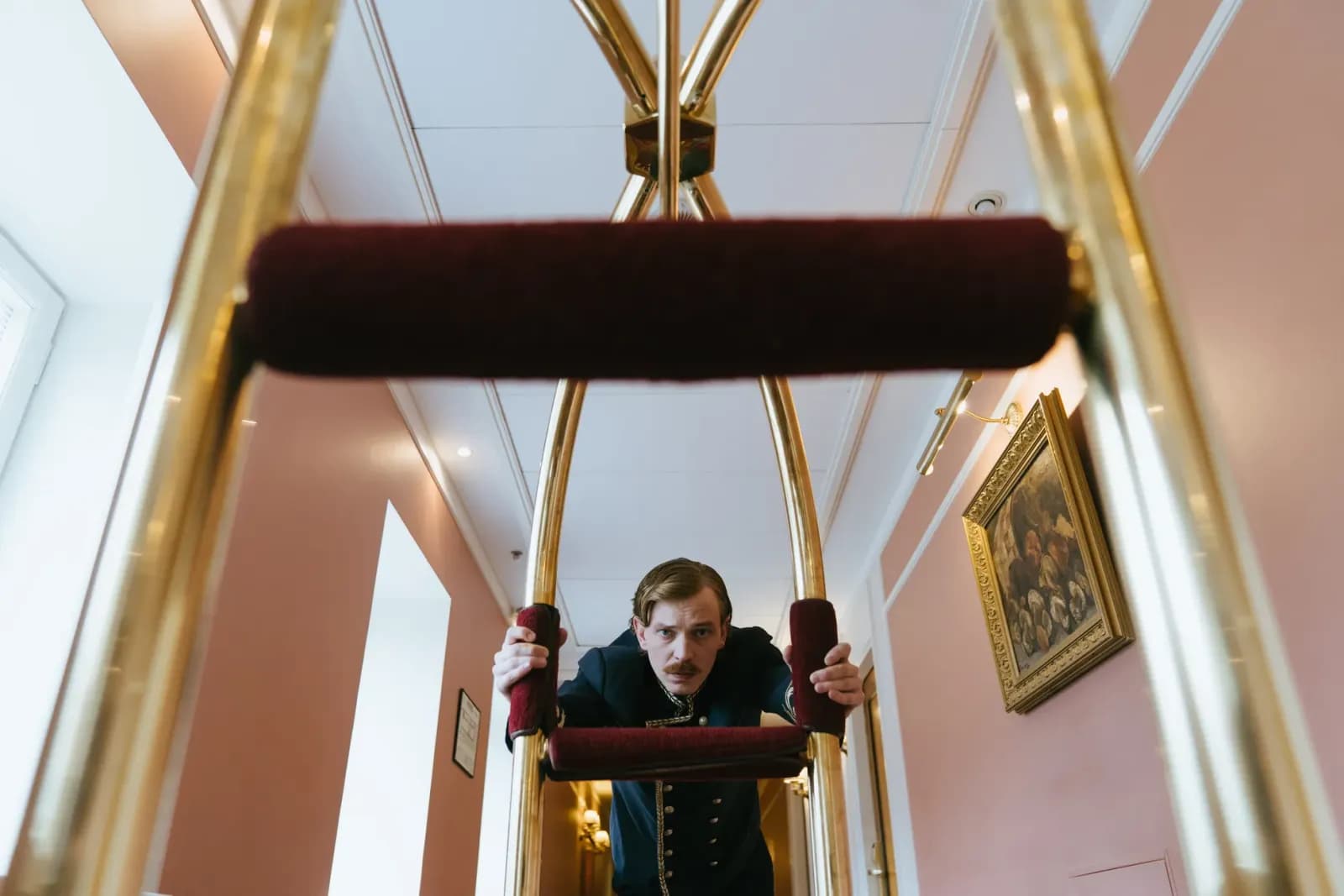 Otel lobisinde misafirlerin bavullarını taşıyan bellboy