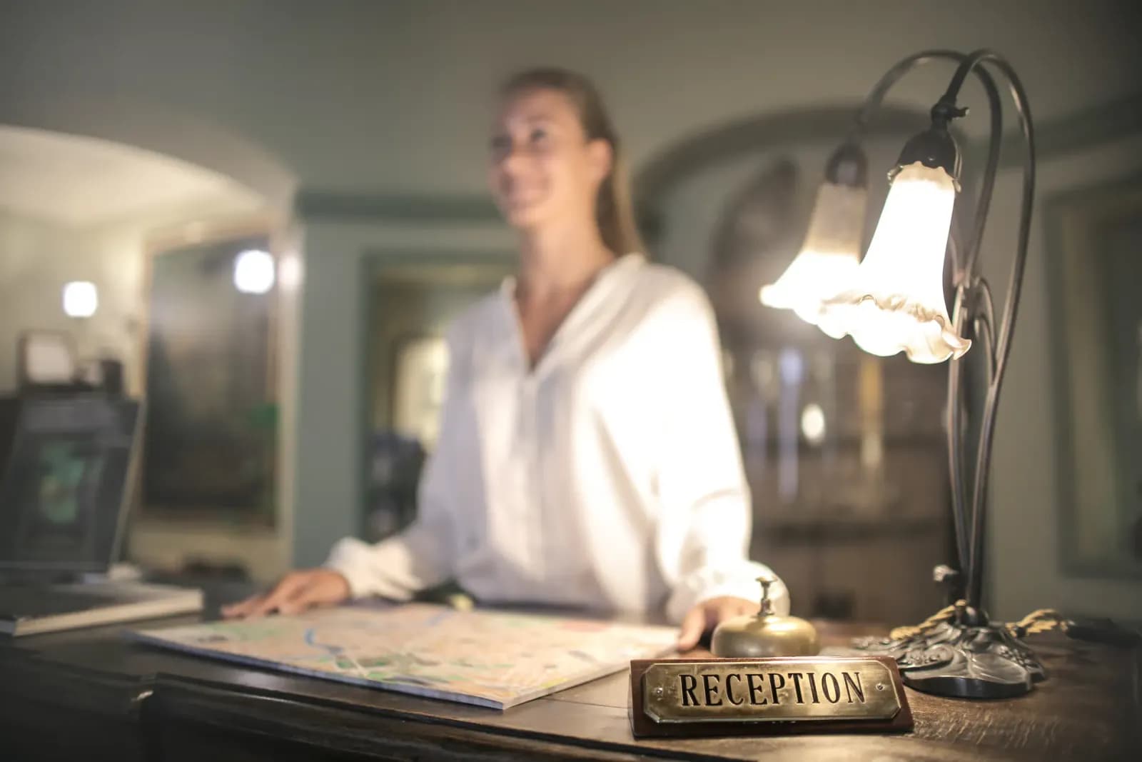 Otel lobisinde misafirleri gülümseyerek karşılayan Guest Relations Görevlisi