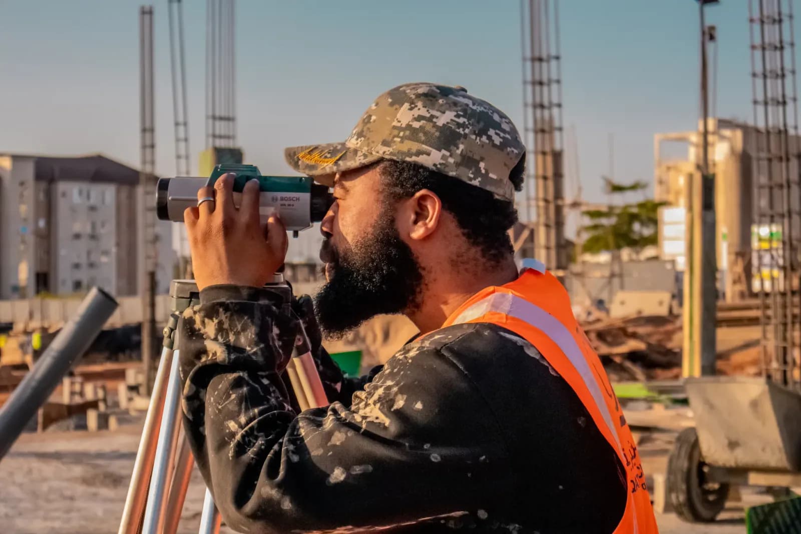 sahada total station cihazı ile ölçüm yapan harita mühendisi