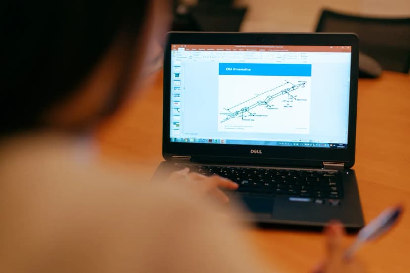 Female engineer working on laptop reviewing technical engineering presentation.