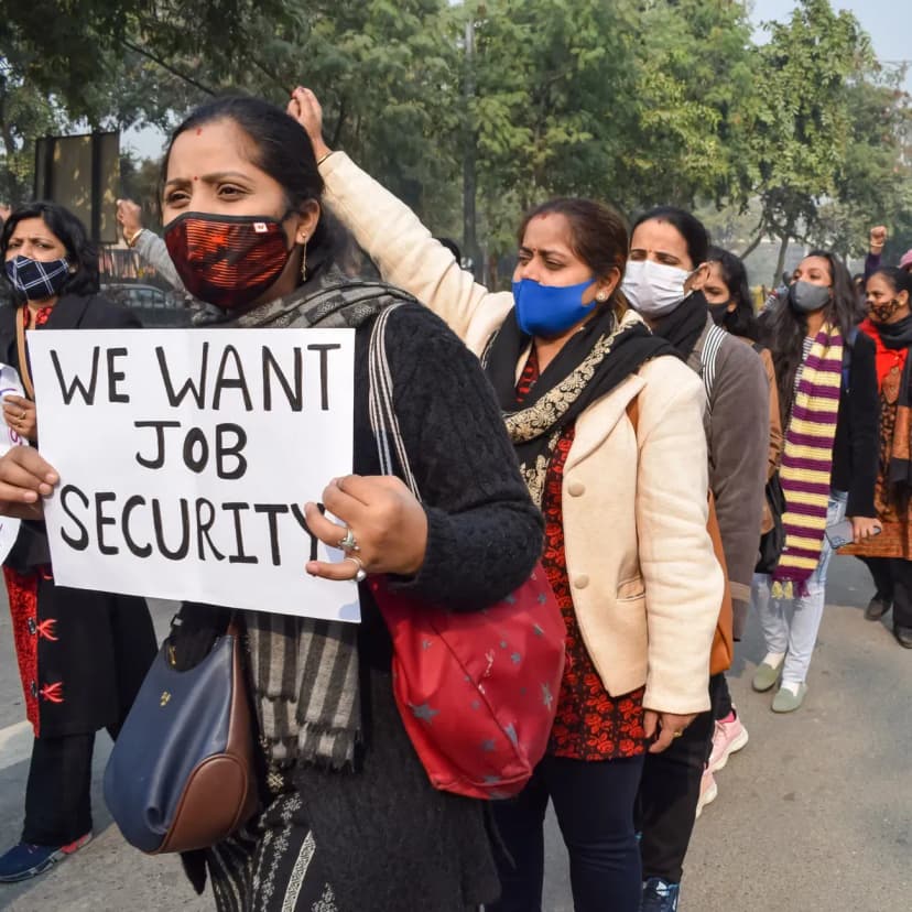 Protestors demand job security during a rally, holding placards outdoors.