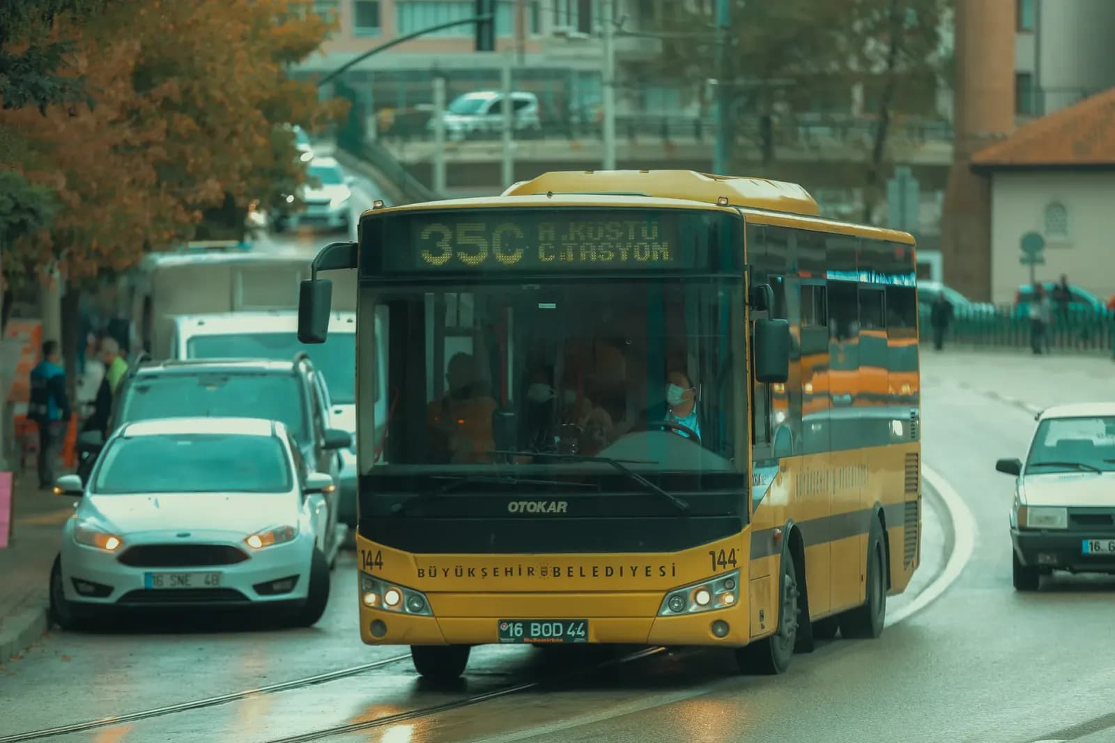 Urban street scene in Bursa, Turkey featuring public transportation bus on a rainy day.