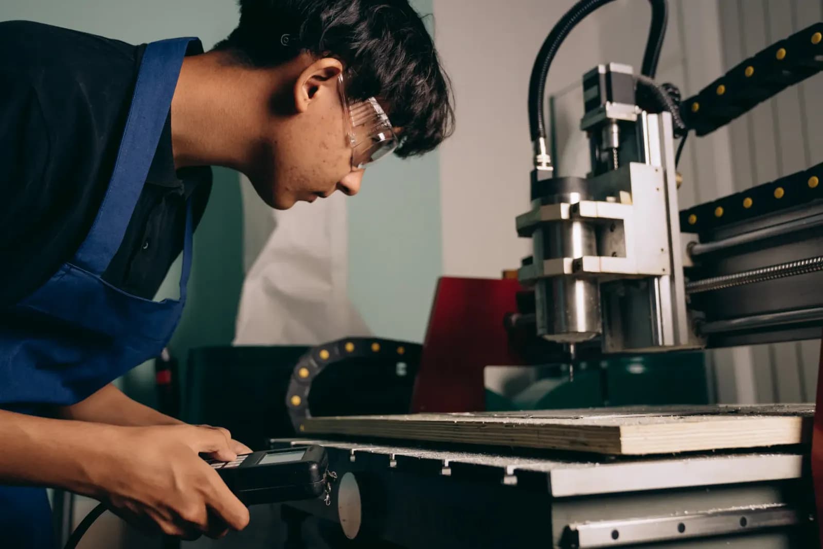 CNC tezgahında çalışan profesyonel operatör | Teknik resim inceleyen bir mühendis veya operatör