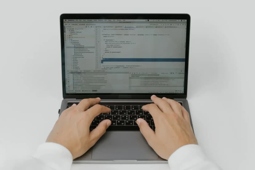 Close-up of hands coding on a laptop, showcasing software development in action.