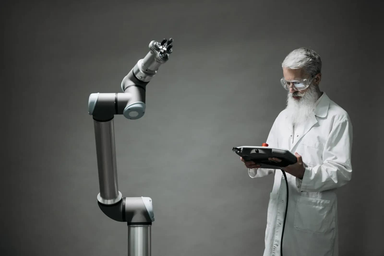 laboratuvarda robotik kol üzerinde çalışan mühendis, dijital kontrol paneli ve grafikler, devre kartı tasarımı yapan mühendis