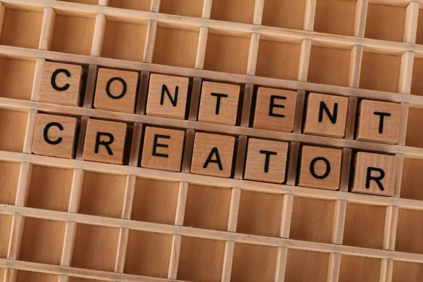 Wooden block letters spelling 'Content Creator' on a grid background. Ideal for digital marketing themes.