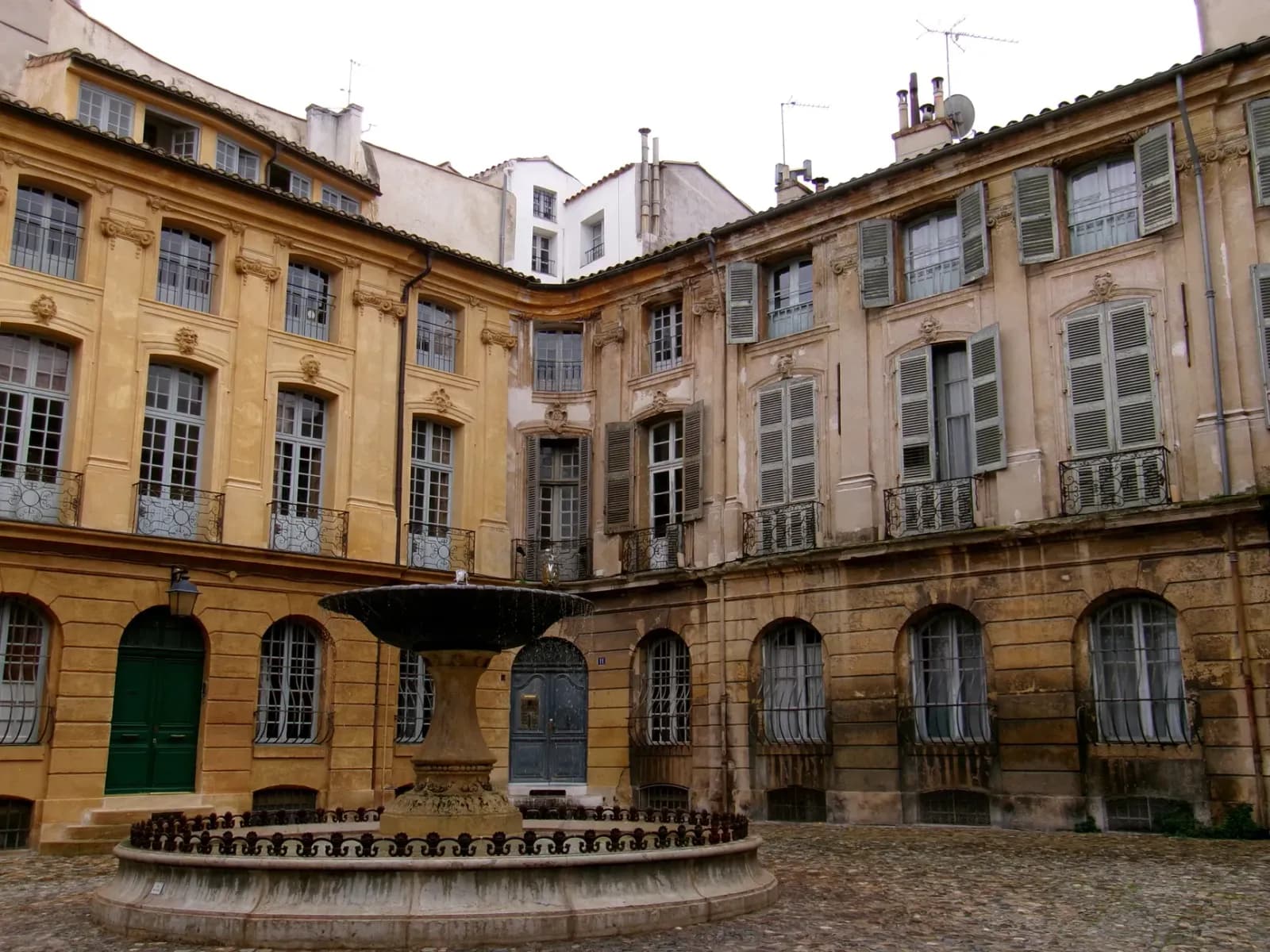 Charming 16th-century architecture in a square with a fountain in Aix-en-Provence, France.
