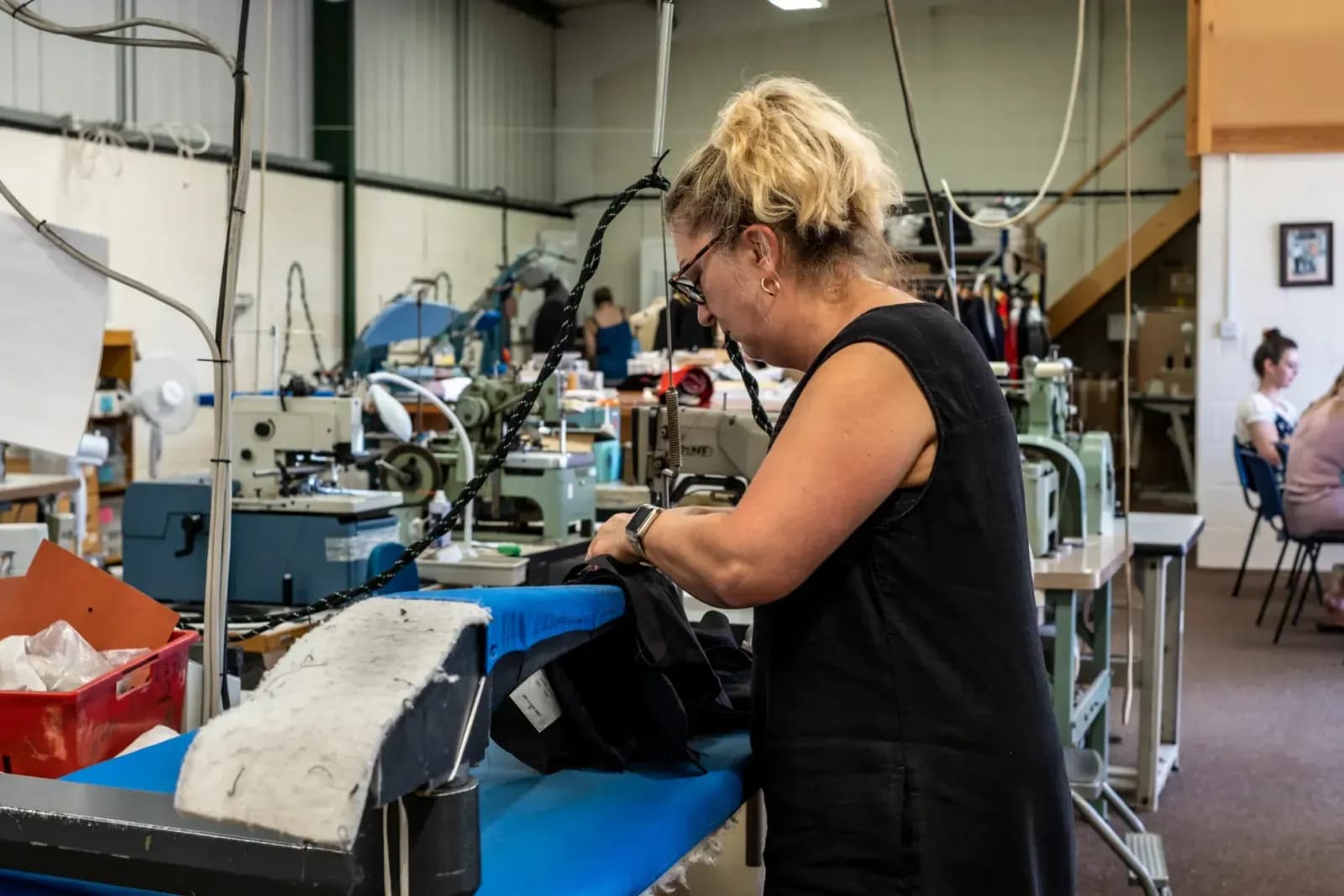 tekstil fabrikasında ütü yapan çalışan, endüstriyel ütü makinesi detayları, paketleme bandında çalışan personel